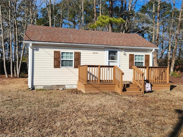 view of front of property featuring roof with shingles, crawl space, a front yard, and a wooden deck