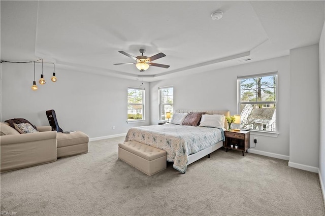 bedroom featuring a tray ceiling, carpet floors, and ceiling fan