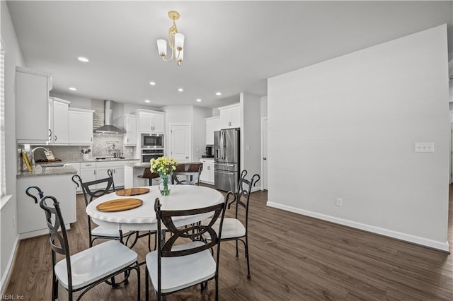 dining room featuring dark hardwood / wood-style flooring, a notable chandelier, and sink