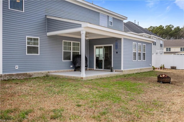 back of property with a patio area, a lawn, and a fire pit