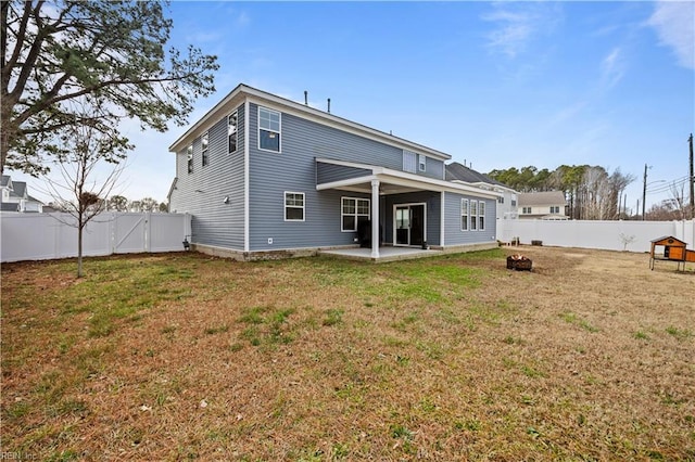 rear view of property featuring a lawn and a patio area