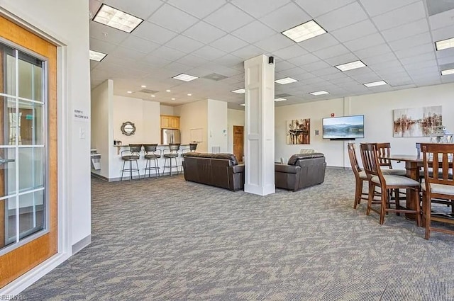 carpeted dining room with a paneled ceiling and decorative columns