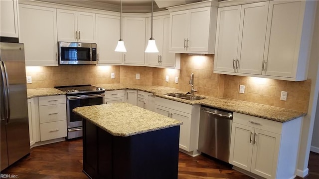 kitchen featuring pendant lighting, sink, appliances with stainless steel finishes, light stone counters, and a kitchen island