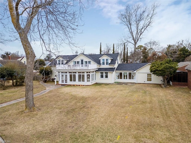 back of property featuring a yard and a sunroom