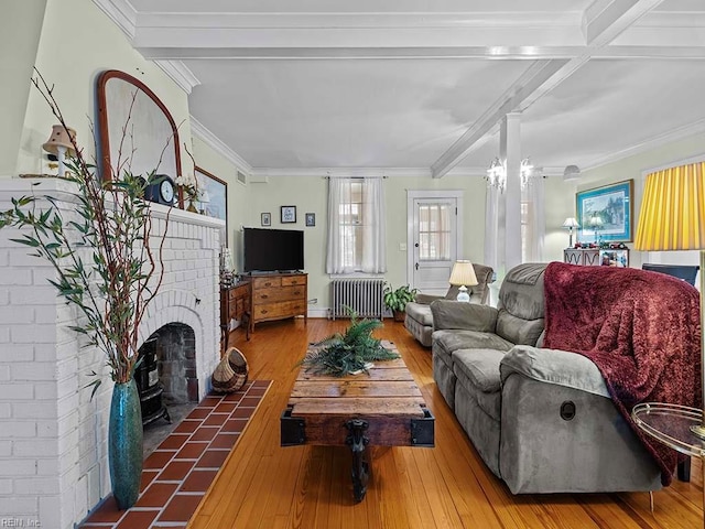 living room with wood-type flooring, ornamental molding, radiator heating unit, and beam ceiling