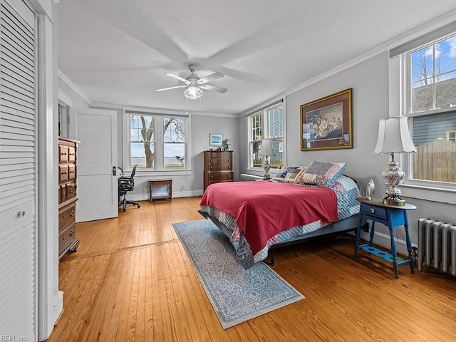 bedroom with crown molding, ceiling fan, wood-type flooring, and radiator
