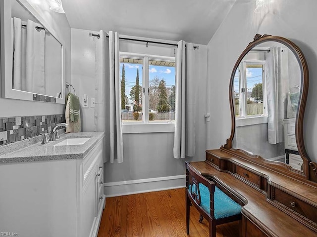 bathroom with wood-type flooring, vanity, and backsplash
