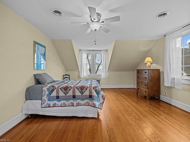 bedroom with light hardwood / wood-style flooring, ceiling fan, and vaulted ceiling
