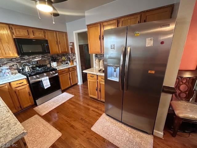 kitchen featuring appliances with stainless steel finishes, dark hardwood / wood-style flooring, and backsplash