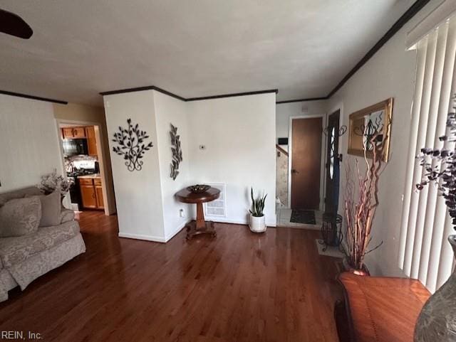 living room featuring dark hardwood / wood-style flooring and crown molding