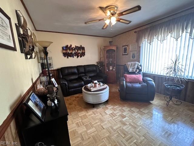 living room featuring ceiling fan, crown molding, and light parquet flooring