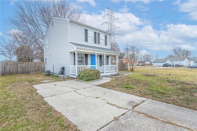 view of front property featuring cooling unit, covered porch, and a front lawn