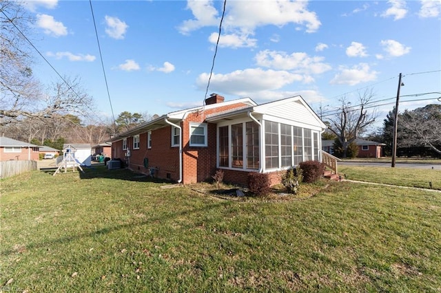 view of property exterior with a yard and a sunroom