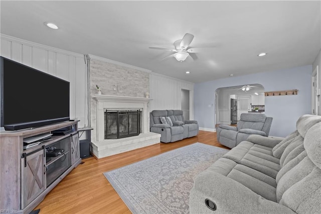 living room featuring ornamental molding, light hardwood / wood-style floors, and ceiling fan