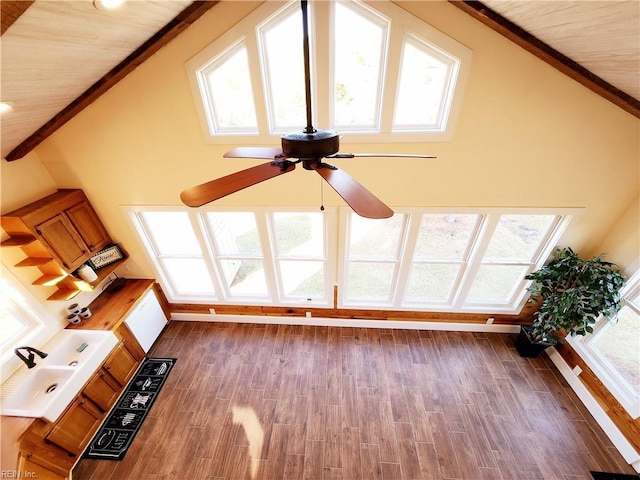 unfurnished living room with ceiling fan, dark wood-type flooring, and high vaulted ceiling