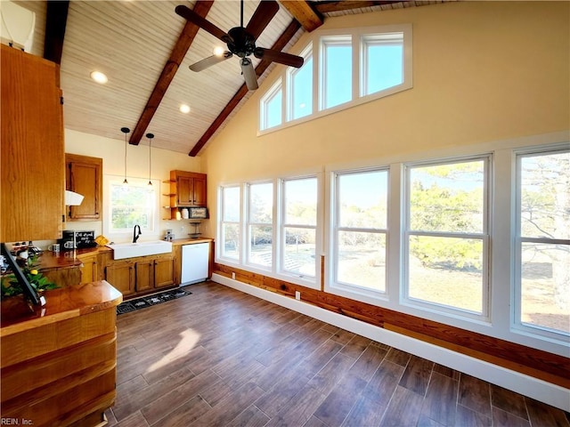 kitchen with sink, beam ceiling, dishwasher, and decorative light fixtures