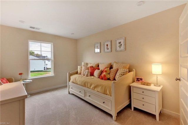 bedroom featuring visible vents, light carpet, and baseboards