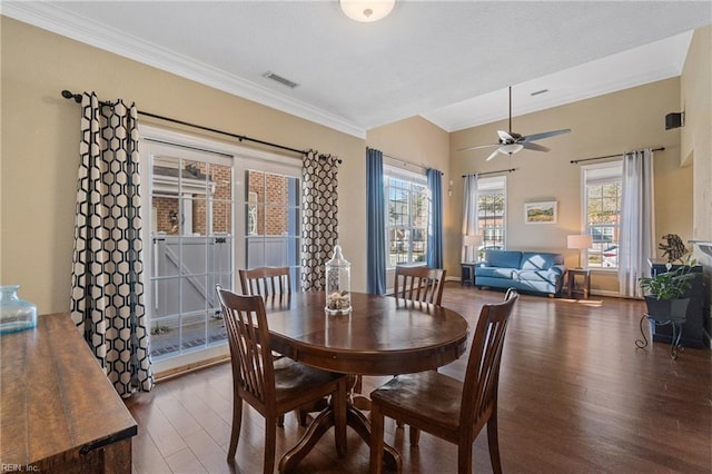 dining area with crown molding, ceiling fan, and dark hardwood / wood-style flooring