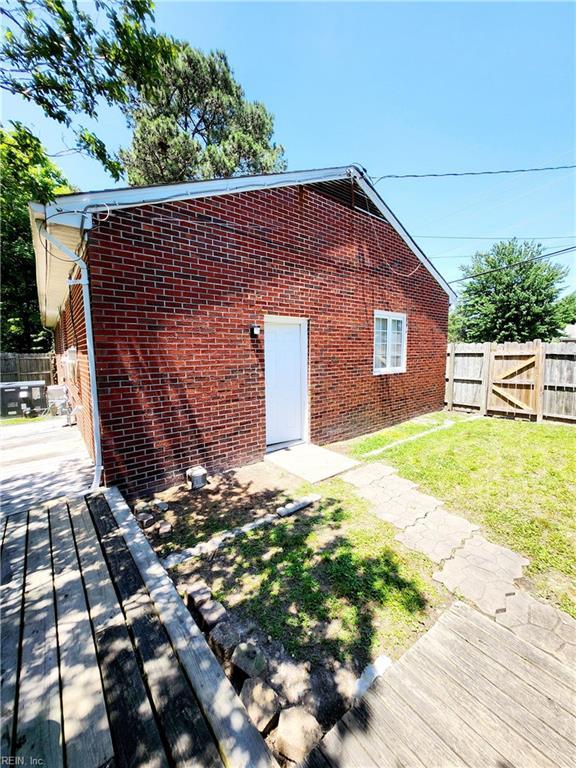 rear view of house with a deck and a lawn