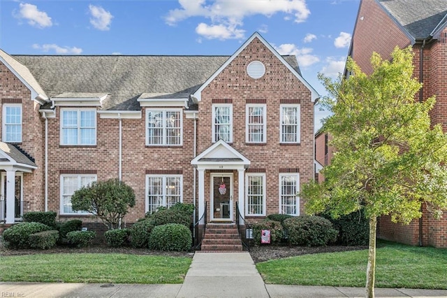 view of front of house with brick siding and a front yard