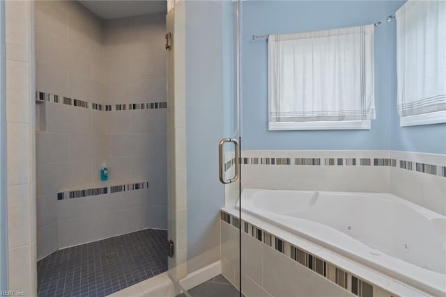 bathroom featuring tile patterned flooring, a jetted tub, and a shower stall