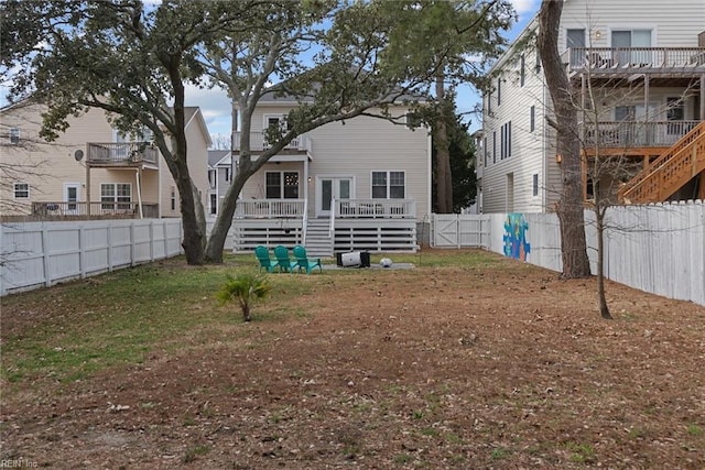 back of property with a yard, a fenced backyard, and a wooden deck