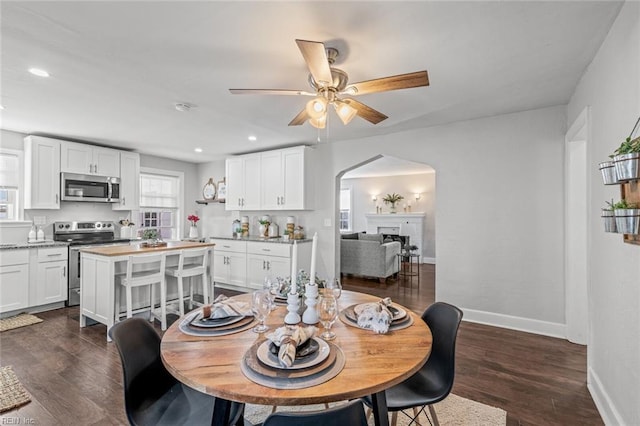 dining area with ceiling fan and dark hardwood / wood-style flooring