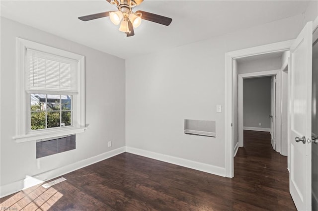 spare room featuring ceiling fan and dark wood-type flooring