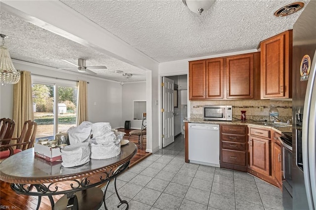 kitchen with light tile patterned floors, ceiling fan, visible vents, appliances with stainless steel finishes, and decorative backsplash