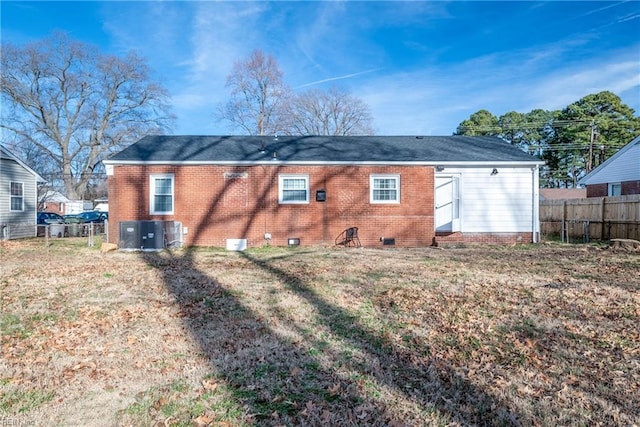 rear view of property with cooling unit and a yard