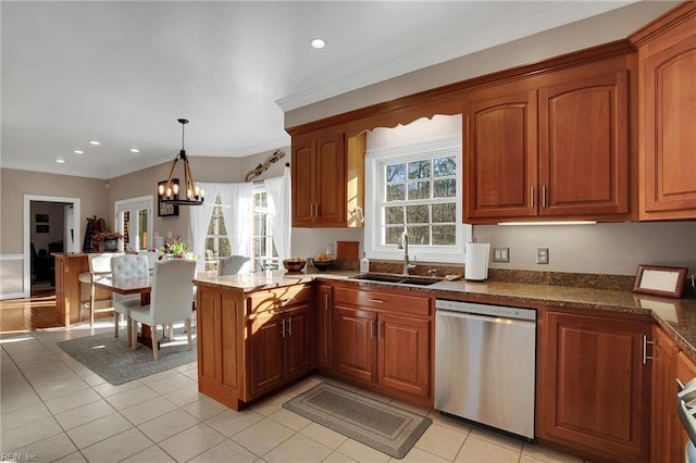 kitchen featuring a peninsula, a sink, stainless steel dishwasher, brown cabinetry, and decorative light fixtures