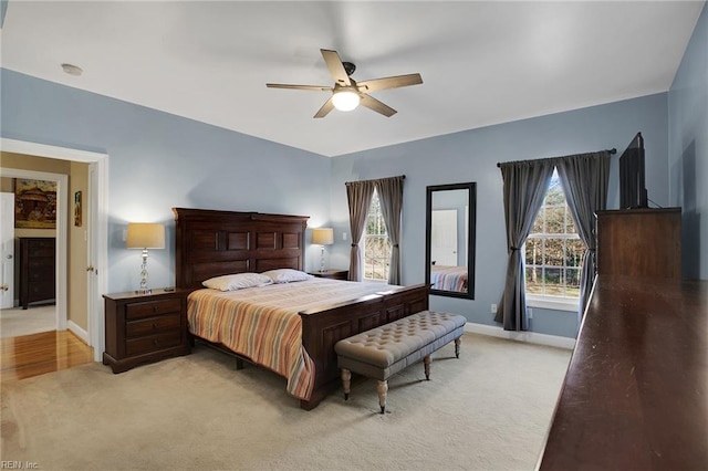 bedroom featuring light carpet, ceiling fan, and baseboards