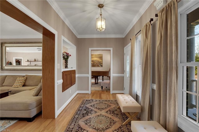 foyer featuring ornamental molding, light wood-style floors, and baseboards