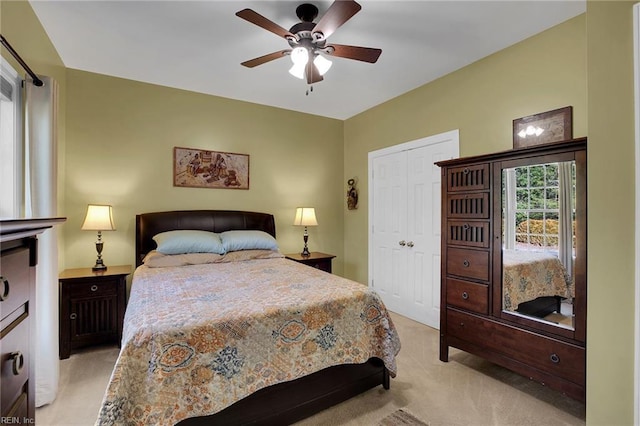 bedroom with light carpet, ceiling fan, and a closet