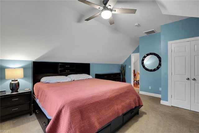 bedroom featuring lofted ceiling, a closet, visible vents, light carpet, and baseboards