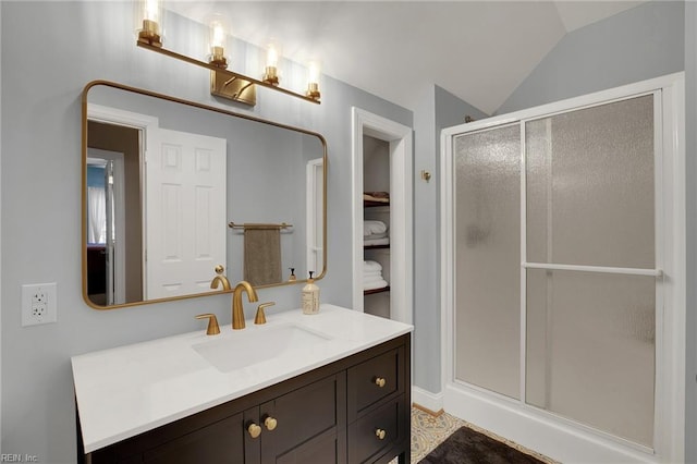 full bathroom featuring lofted ceiling, a stall shower, and vanity