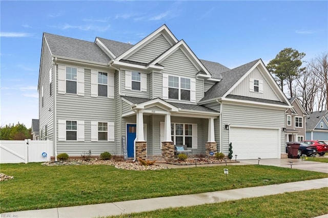 view of front of property featuring a garage, a porch, and a front lawn