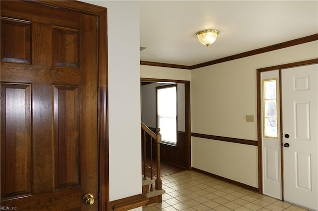 tiled entrance foyer featuring crown molding