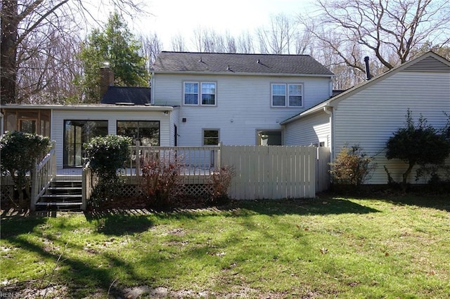 rear view of house with a yard, a deck, and a sunroom