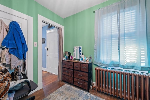 bedroom featuring radiator and dark hardwood / wood-style floors