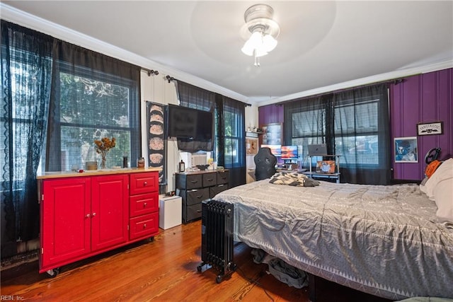 bedroom with wood-type flooring and ornamental molding