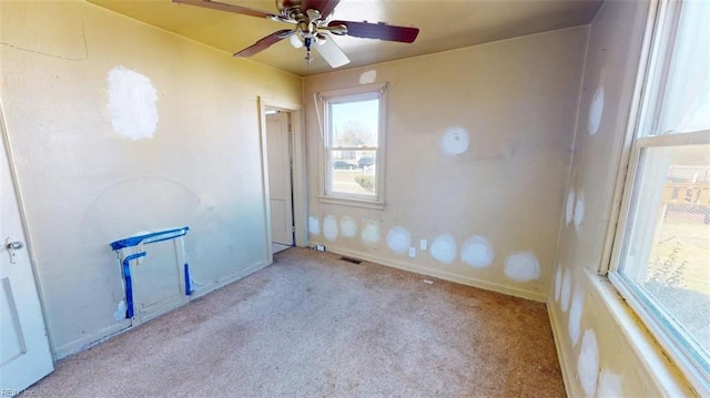 unfurnished room featuring light carpet, baseboards, visible vents, and a ceiling fan