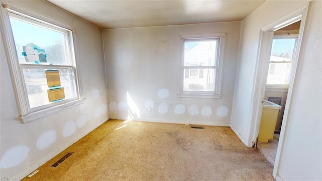 empty room with visible vents and light colored carpet