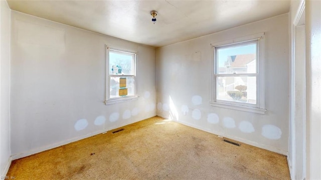 carpeted spare room featuring visible vents