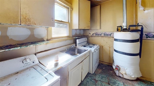 kitchen featuring independent washer and dryer, white range with gas stovetop, light countertops, and a sink