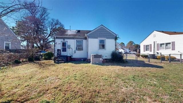 back of house featuring central AC unit, fence, and a yard