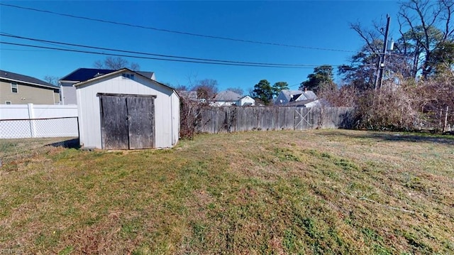 view of yard featuring a fenced backyard, a storage unit, and an outdoor structure