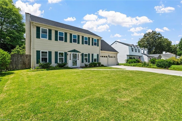 colonial inspired home featuring a garage and a front lawn