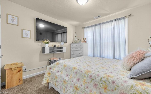bedroom with baseboards, visible vents, and carpet floors