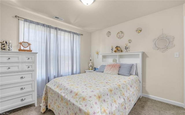 carpeted bedroom featuring visible vents and baseboards